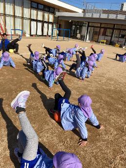 コーチとボール遊びをする5歳児