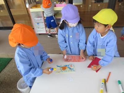 園庭で好きに鯉のぼりをつくるこどもたち