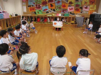 ALT英語活動の先生に絵本をよんでもらう4歳児