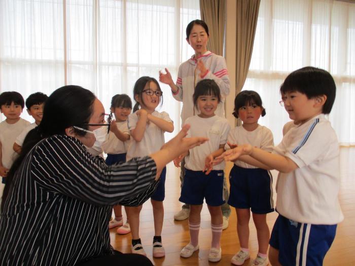 ALT英語活動に参加し、タッチをする4歳児