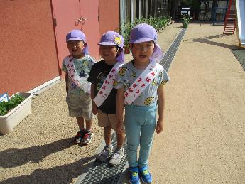 挨拶運動の当番のたすきをつける5歳児