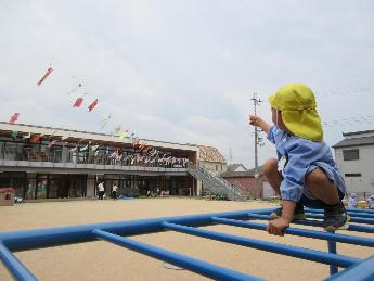 うんていに登ってこいのぼりをみる4歳児