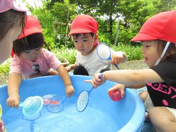 金魚すくいをする0・1歳児