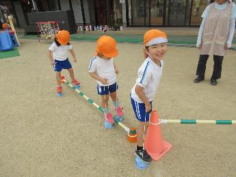 障害物をまたいでぱかぽこを歩く3歳児