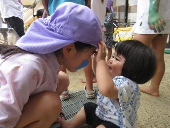 ぬたくりをして遊ぶ5歳児と0歳児