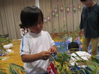 七夕飾りをつける4歳児