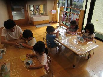 2歳児、皿に筆で色付け