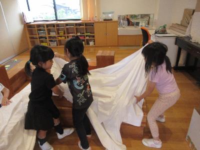 台に布をかけるこどもたち