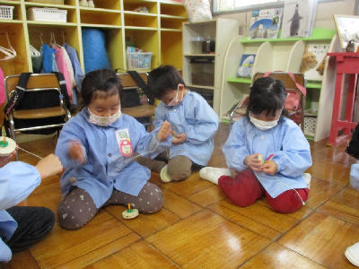 コマ回しで遊ぶ4歳児