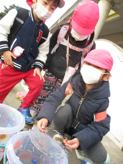 穴ぼこの氷を見せる4歳児