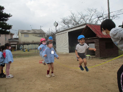 5歳児と一緒にお縄跳びをする4歳児