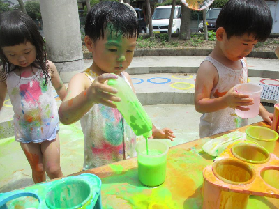 全身を使い絵の具で遊ぶ年少児