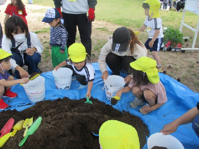 親子で苗植えをする年少児