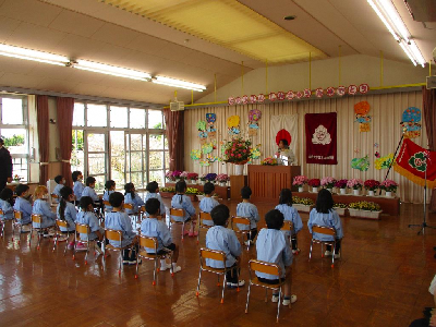 進級式で園長先生の話を聞く園児