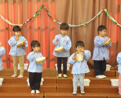 タンバリンをたたく園児