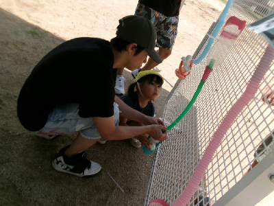 お父さんと一緒に水遊びをする園児