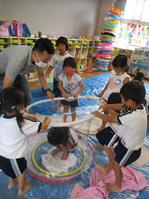 大きなシャボン玉を作る園児とお父さん
