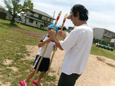 親子で一緒につくった竹馬に乗ってみる年長児