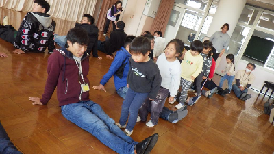 お父さんの足の間をジャンプする園児