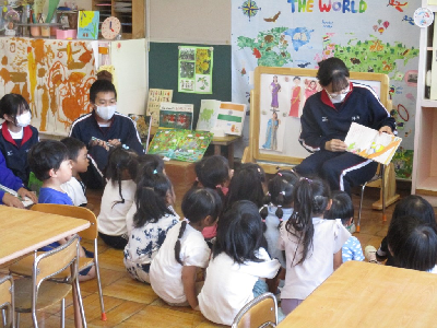 中学生のが読む絵本を見る園児