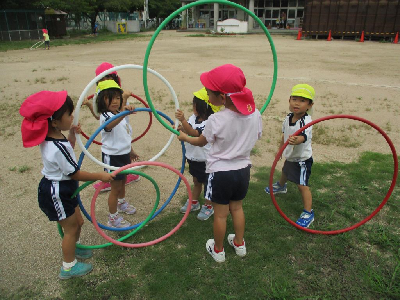 フープで五輪をつくって遊ぶ園児