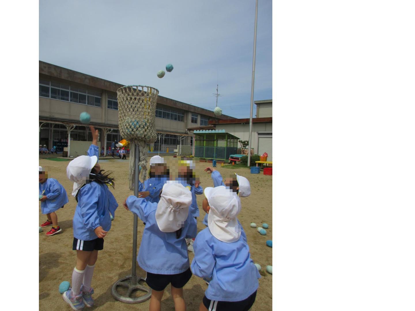 玉入れ籠に向かって玉を投げる幼児たち