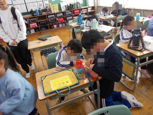 5年生が園児と折り紙をしている様子