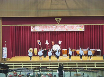 幼稚園の子たちが、桃太郎の歌を歌いながら、腕を突き上げている様子。