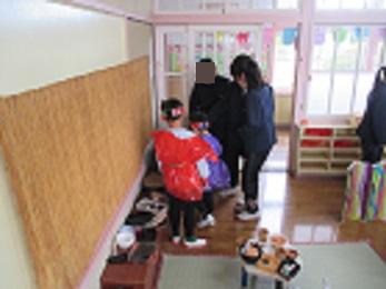幼稚園の子たちが作った昔の台所セットで、一緒に遊ぶ5年生たち