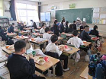 5年生と2年生の児童が、同じ教室で給食を食べている様子