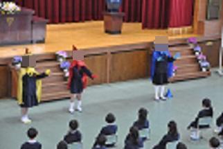西神吉小学校のマスコットキャラクター、ピッカリ星人が、新1年生の前で挨拶をする様子。