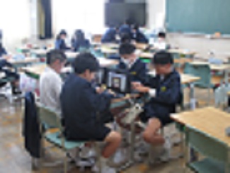 雨の日の休み時間の様子。教室で、タブレットを使ってタイピングゲームをしている。