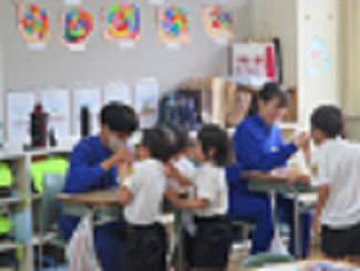 トライやるの中学生が、1年生を相手に腕相撲をしてあげている様子。