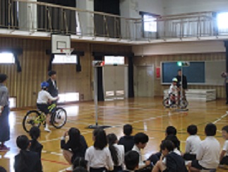 3年生の中で自宅から自転車を持ってきた児童が、交差点の二段階右折の訓練を受けている。