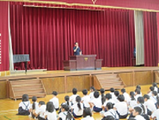 臨時の全校朝会で、教頭が児童たちに話をしている。