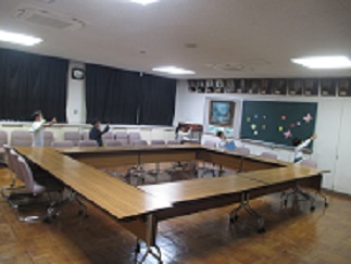 2年生と1年生が会議室に入り、歴代の校長先生の写真を見ている。