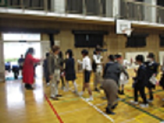 児童が体育館を出るときに、劇団員が出口に並び、児童とハイタッチしている。