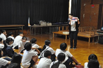 養護教諭が歯と歯ブラシの模型を使って、正しい歯の磨き方を5年生に指導している。
