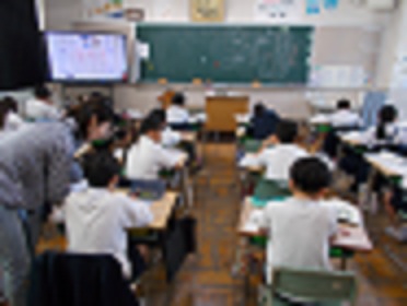 国語の授業風景。児童がノートに書いている間、教師は児童の席を巡り、必要に応じて指導をしている。