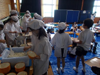 多目的室で、保育園の子たちのために5年生が給食の準備をしている。