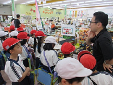 児童がふぁーみん店内で、商品についての話を聞いている様子。