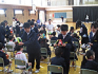 1年生を迎える会で、6年生が作った冠を1年生にかぶせている。