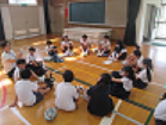 児童たちが児童集会で、縦割り班であつまって次の日の遊びの計画を立てている。