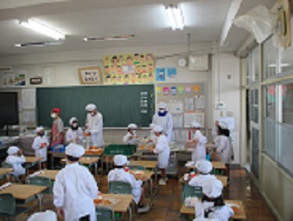 給食の時間、中学生が児童たちと一緒に準備をしている。