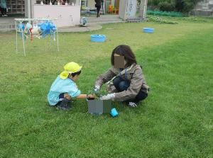 4歳児が保護者と一緒にミニトマトを植えている
