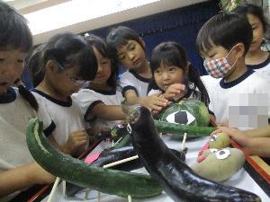 5歳児がお供えの野菜を見ている