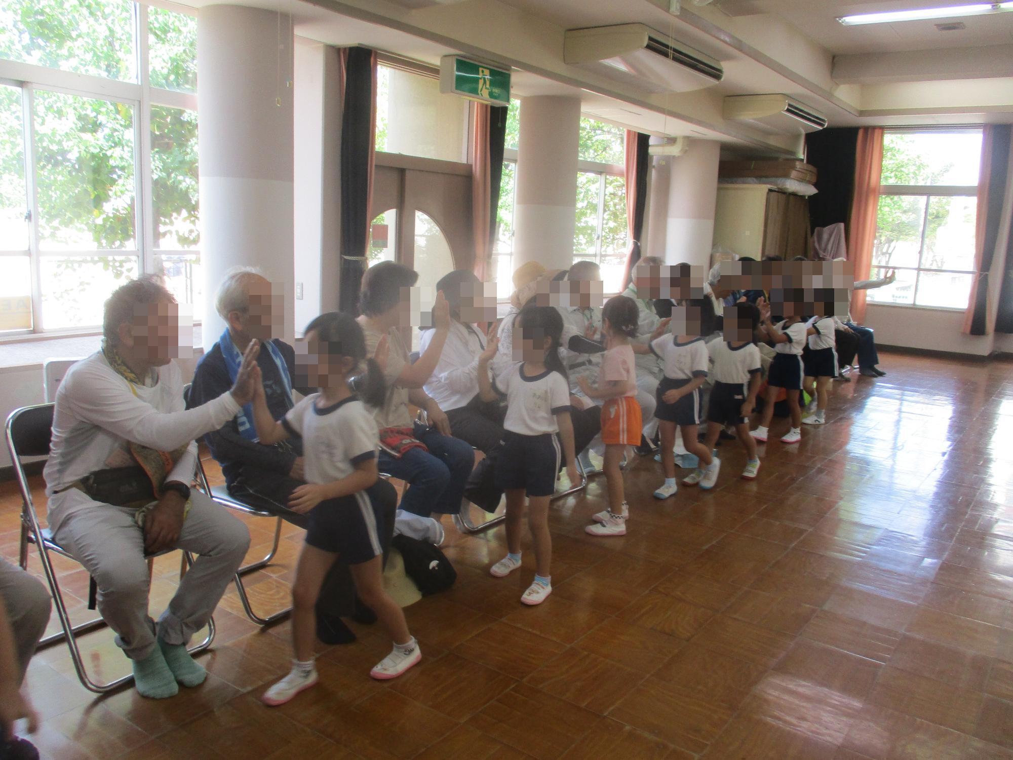 いなみの老人大学の皆さんとタッチする園児