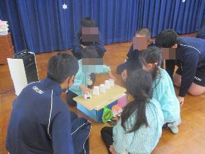 中学生が作ったおもちゃで幼児が遊んでいる