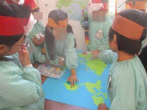 5歳児のサンタが世界地図を見て会議をしている