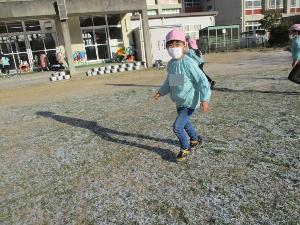5歳児が芝生に残った雪でスケートをしている